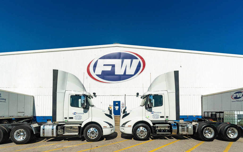 Fw Trucks In Front Of Large Warehouse