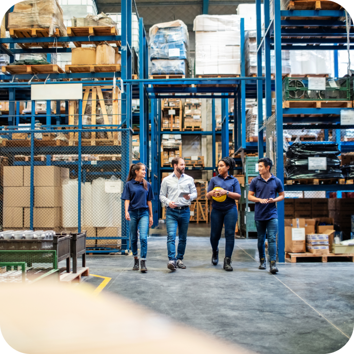 group of two men and two women walking through a warehouse